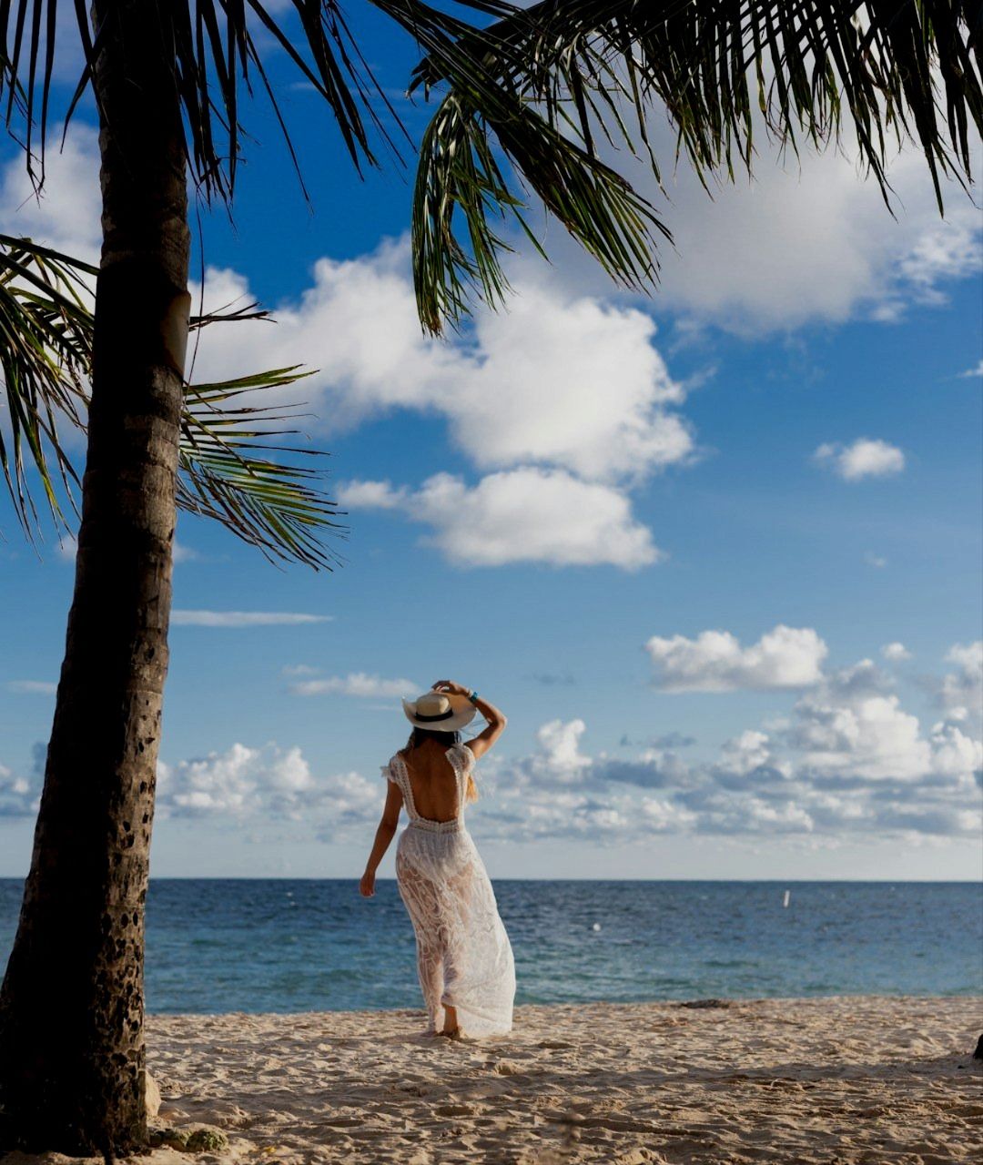 Femme avec un chapeau sur une plage paradisiaque en Colombie.